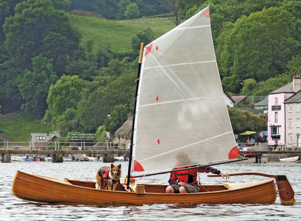 Sailor and a dog aboard the ELLAJEN sailing canoe.