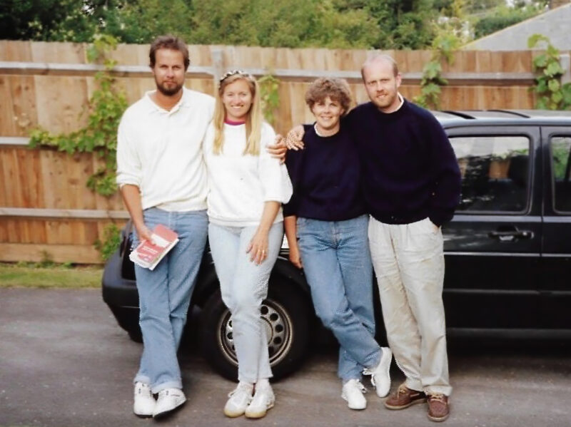 Four friends gathered in front of a car