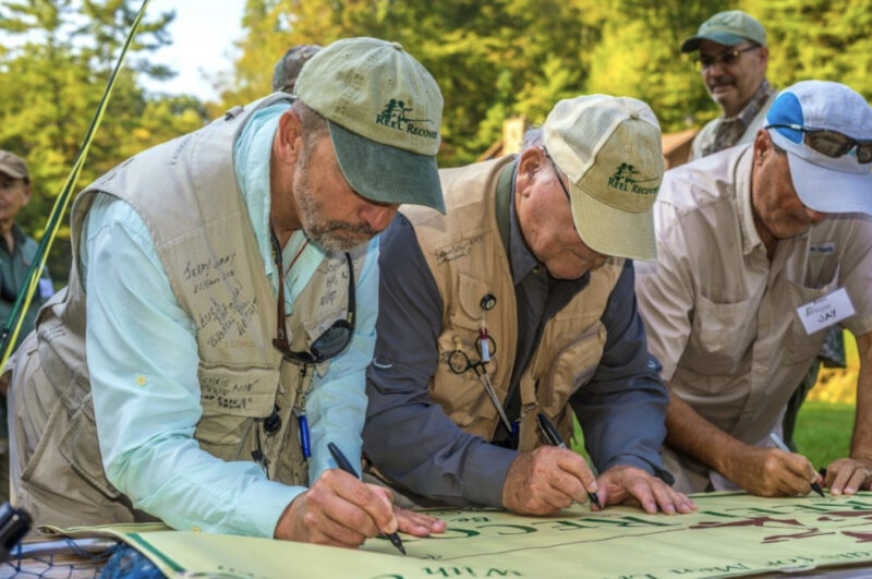 Reel Recovery participants sign weekend banner.