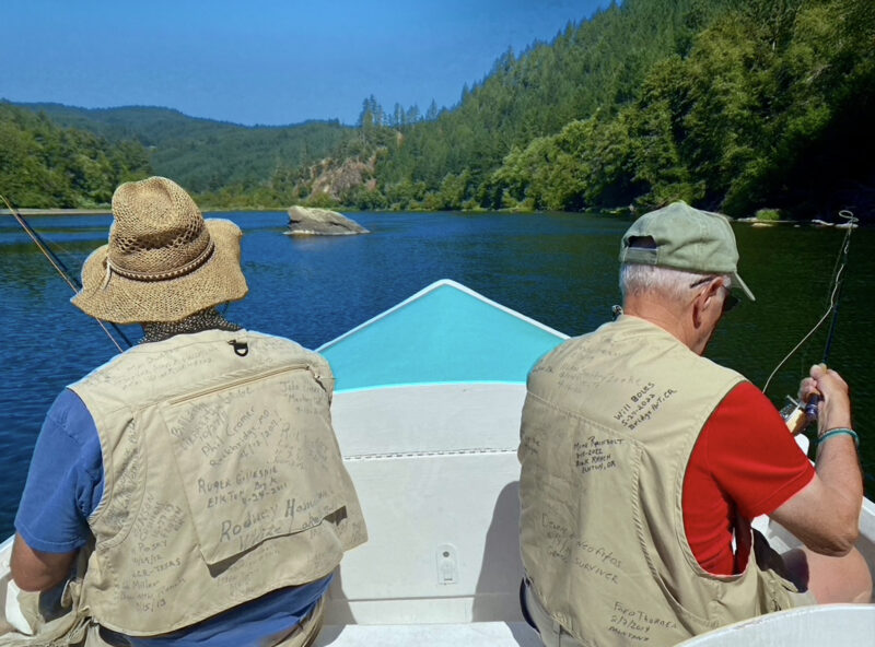 Two men fly fishing from the bow of a boat.
