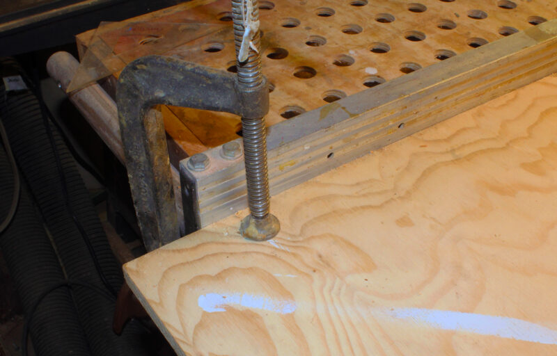 Clamping a plywood base against a fence.