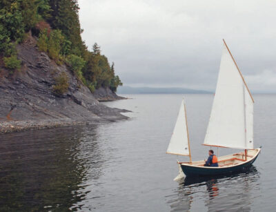 Small sailboat with white sails on Lake Champlain.
