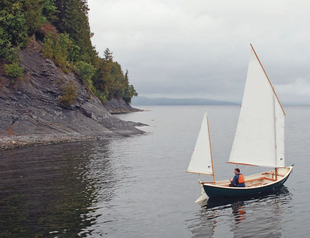 Small sailboat with white sails on Lake Champlain.