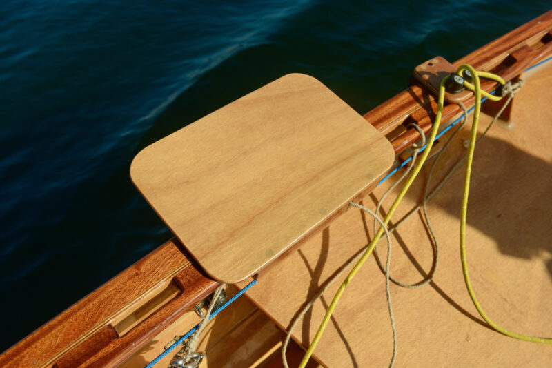 Hiking seat attached to the rail of a boat.