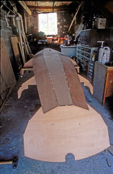 Stitch-and-glue boat under construction in a tight workshop.