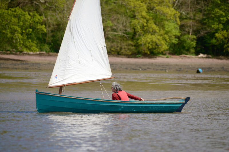 Man sailing blue-painted Western Skiff.