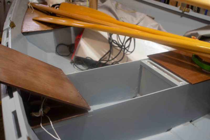 Under-seat lockers in small wooden boat.