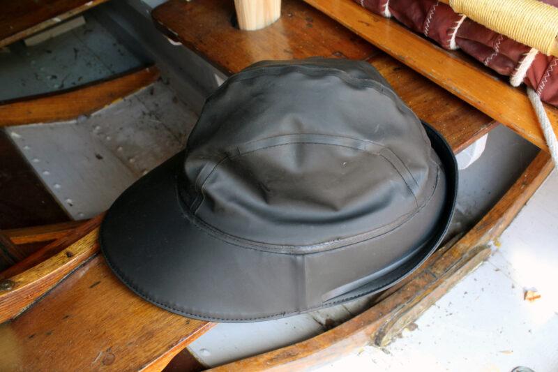 Black sou‘wester on a wooden boat thwart.