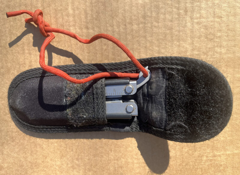 Gerber Mutil-Plier 600 in nylon sheath with red lanyard.