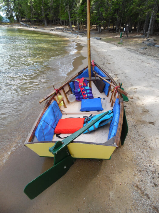 Flat-bottomed skiff on sandy beach.