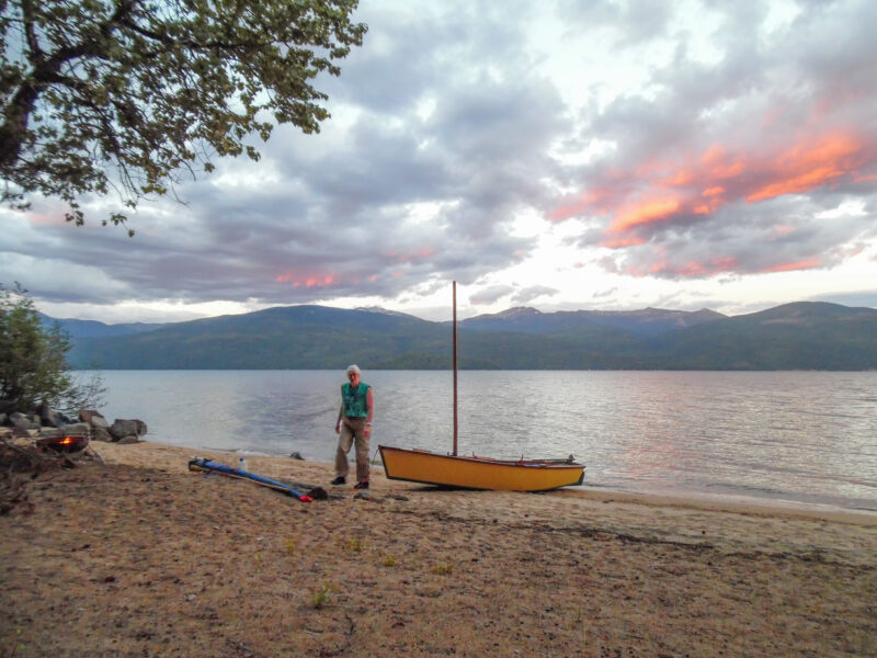 Woman beaches a small boat on a sandy beach in Priest Lake, Idaho.