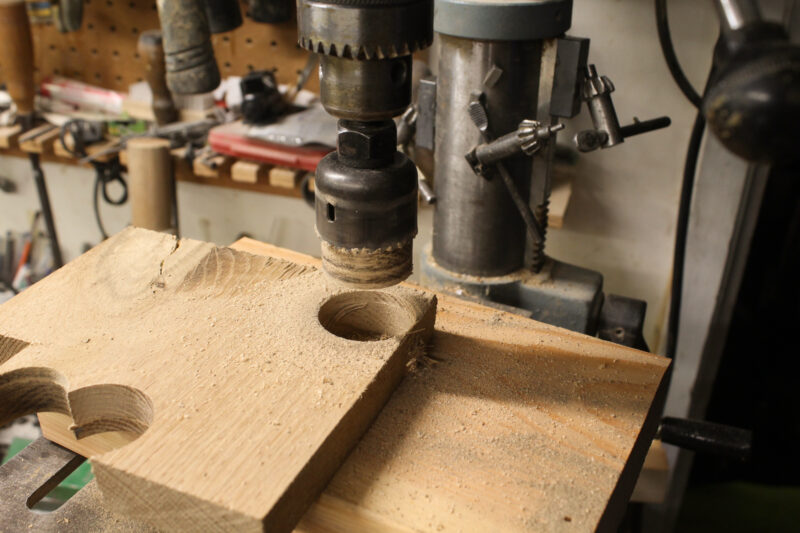 Cutting a wooden plug with a holesaw.