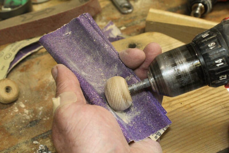Hand sanding a parrel bead to shape.