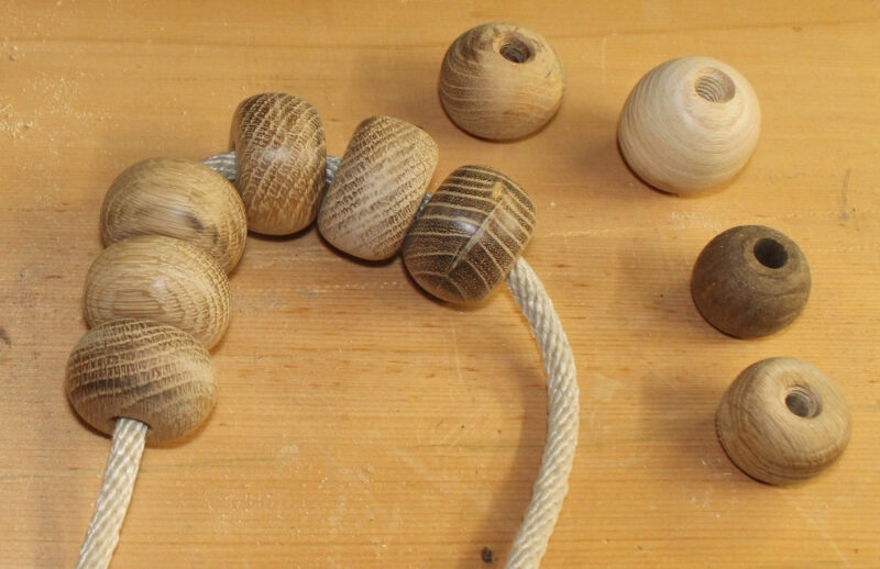 A collection of hand-made wooden parrel beads threaded on 1⁄4″ line.
