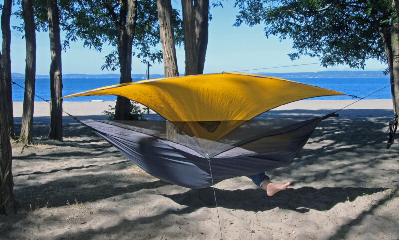 A person climbing into a bottom-entry Hennessy hammock.
