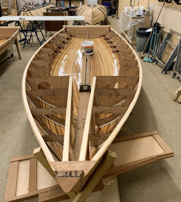 Strip-planked sailing dinghy under construction in boatshop