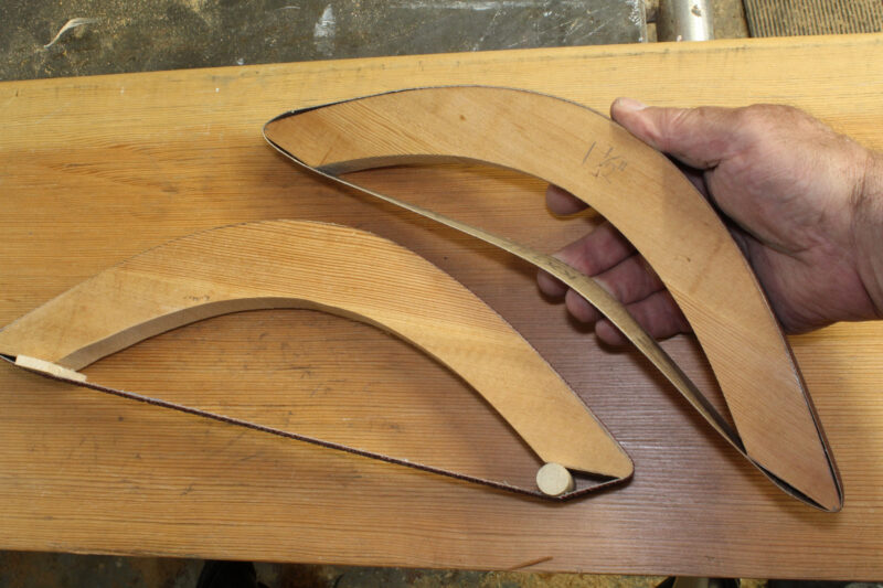 A man demonstrates how to adjust the tension on a sanding-bow belt with the addition of shims and dowels.