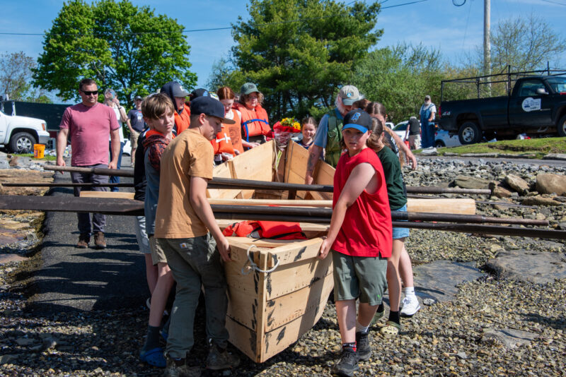 A group of middle-school students launch a newly built bateau.