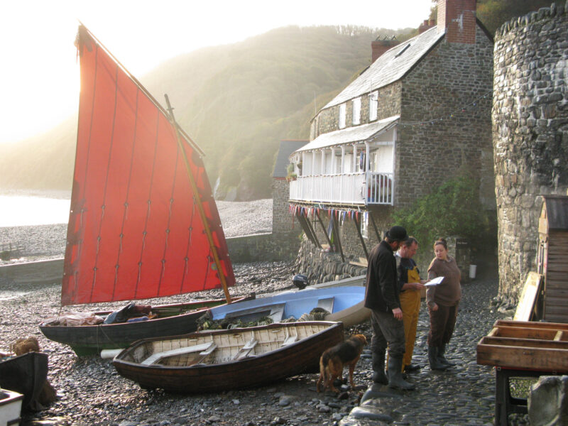 Small boats pulled up on a steeply shelving pebble beach.