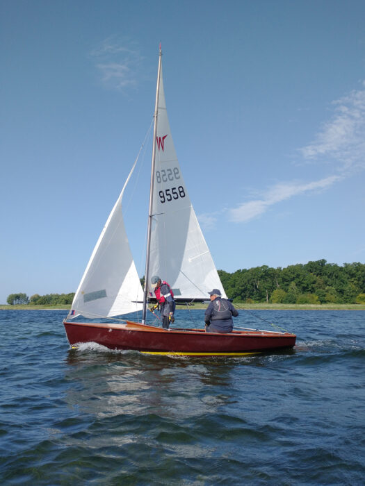 Wayfarer sailing dinghy under full rig with two-man crew.